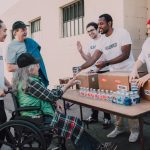 Voluntários distribuem água engarrafada e mantimentos a pessoas em uma ação comunitária de apoio.